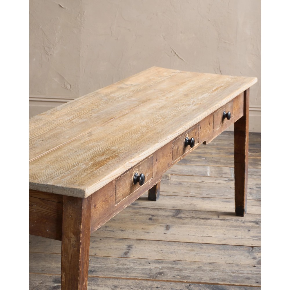 A long natural pine scullery table featuring three drawer fronts with dark wooden knobs and straight legs. View VIII