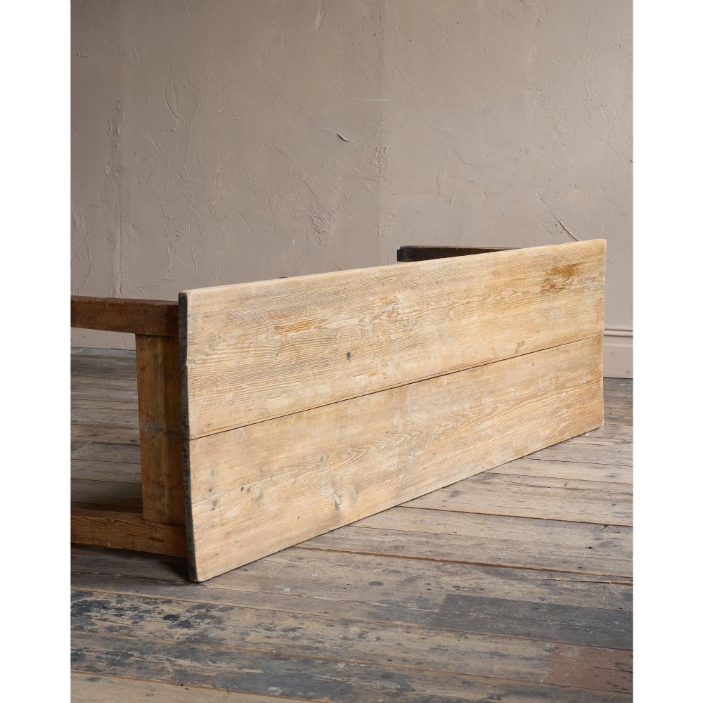 A long natural pine scullery table featuring three drawer fronts with dark wooden knobs and straight legs. View XIII