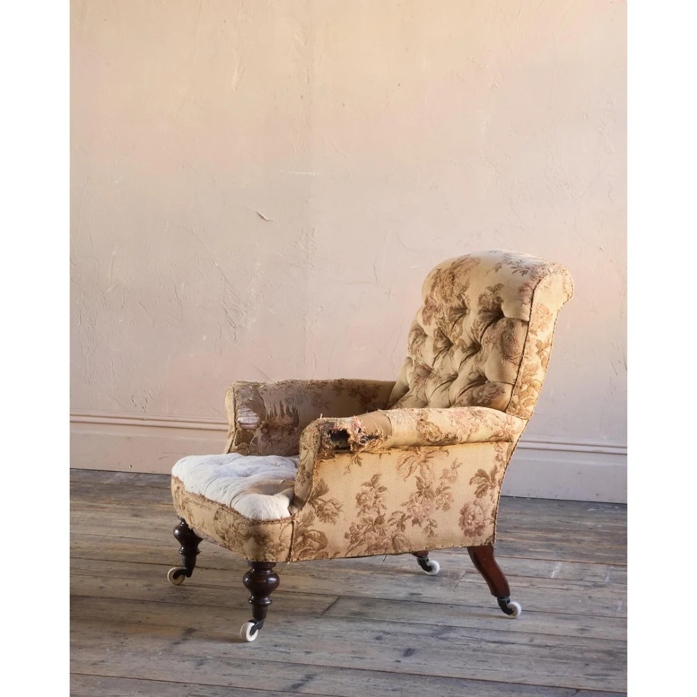 A 19th-century Victorian library armchair upholstered in beige floral pattern fabric with deep buttoning, turned front legs on castors, and an attached adjustable mahogany reading stand. View III