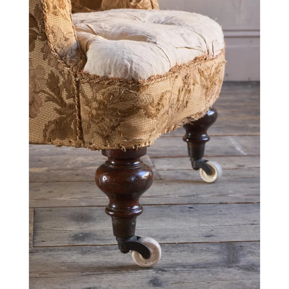 A 19th-century Victorian library armchair upholstered in beige floral pattern fabric with deep buttoning, turned front legs on castors, and an attached adjustable mahogany reading stand. View XII