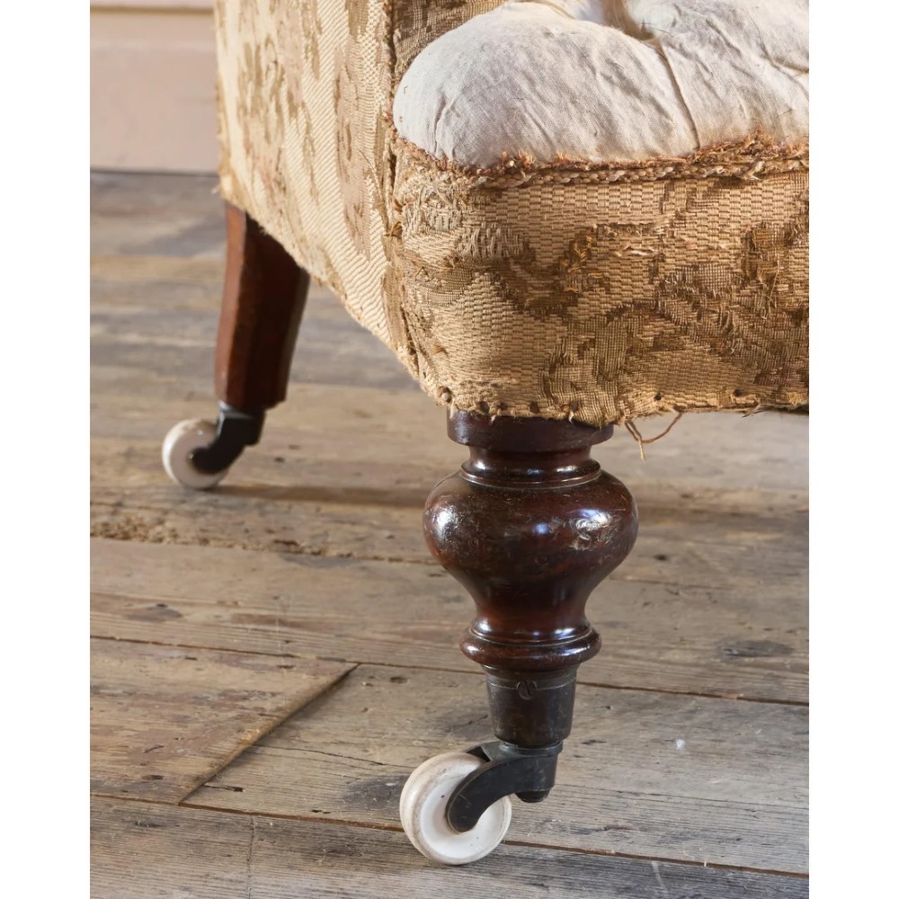 A 19th-century Victorian library armchair upholstered in beige floral pattern fabric with deep buttoning, turned front legs on castors, and an attached adjustable mahogany reading stand. View XIII