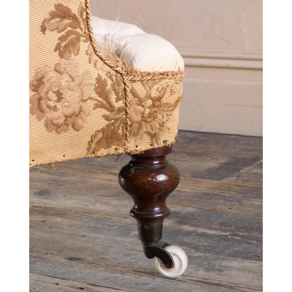 A 19th-century Victorian library armchair upholstered in beige floral pattern fabric with deep buttoning, turned front legs on castors, and an attached adjustable mahogany reading stand. View XV