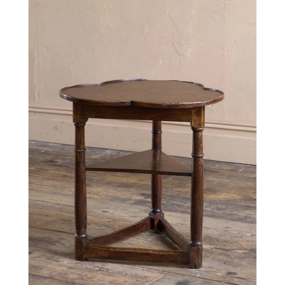 An 18th-century dark oak cricket table featuring a trefoil-shaped top, three turned legs, a triangular lower shelf, and a stretcher base. View II