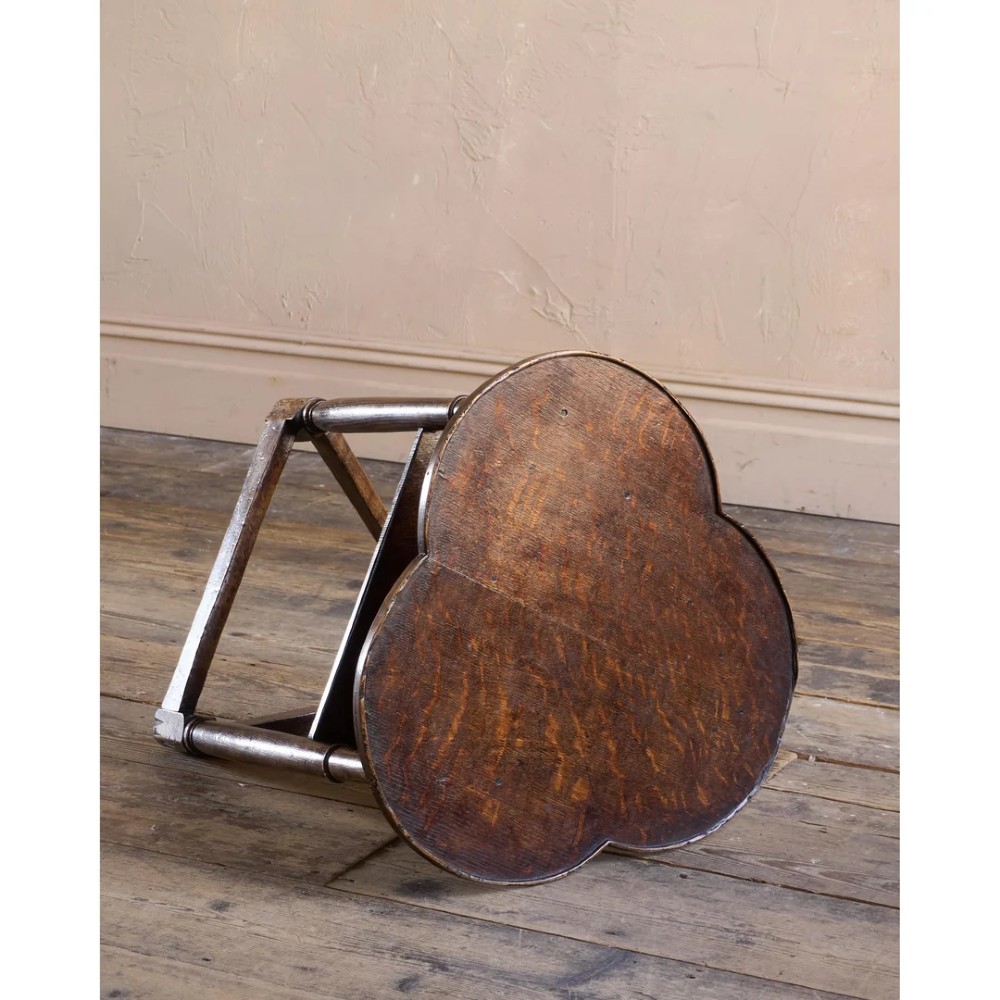 An 18th-century dark oak cricket table featuring a trefoil-shaped top, three turned legs, a triangular lower shelf, and a stretcher base. View III