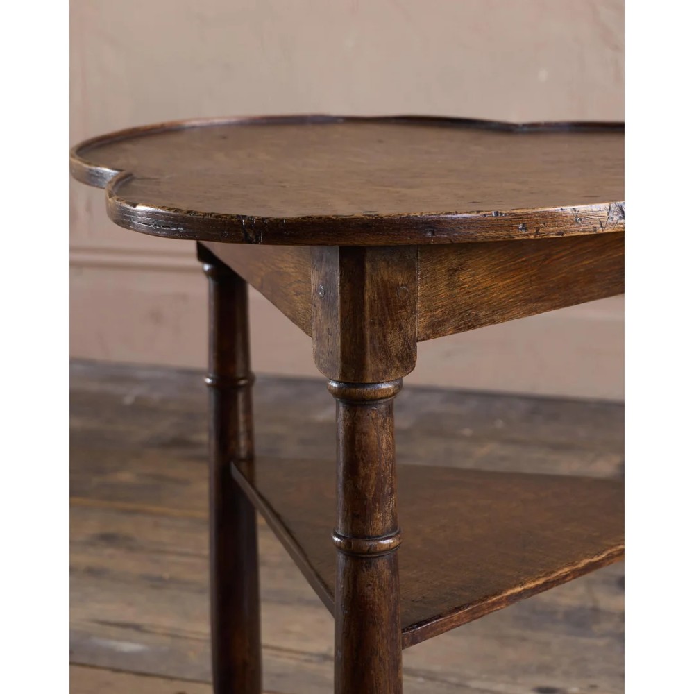 An 18th-century dark oak cricket table featuring a trefoil-shaped top, three turned legs, a triangular lower shelf, and a stretcher base. View XIII