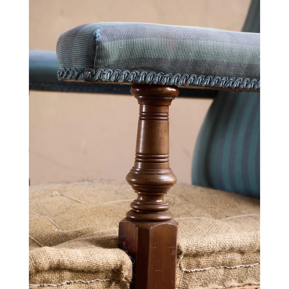 A Victorian mahogany open armchair with turned front legs, brass castors, open padded arms, and blue striped fabric upholstery. View VIII