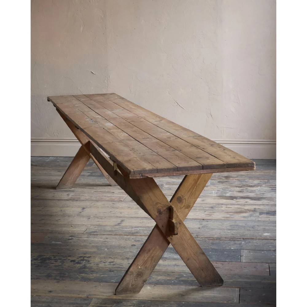 A long, narrow rustic wooden dining table featuring a thick plank top supported by X-frame trestle legs and a longitudinal stretcher. View IV