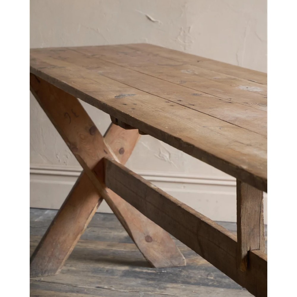A long, narrow rustic wooden dining table featuring a thick plank top supported by X-frame trestle legs and a longitudinal stretcher. View XI