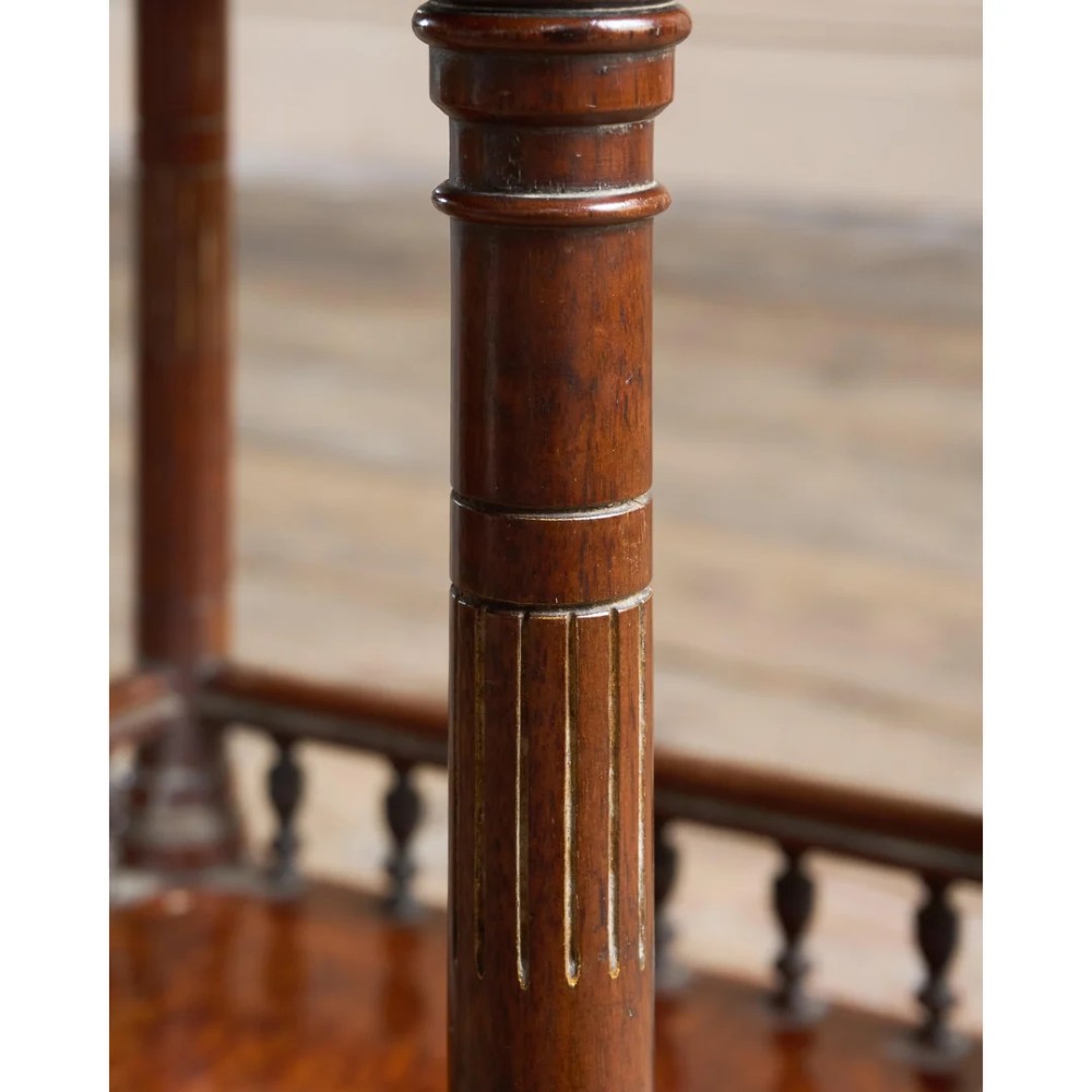 An octagonal Victorian side table featuring an amboyna wood veneer top with gilt borders, turned legs, a lower shelf with a spindle gallery, and brass castors. View XIII