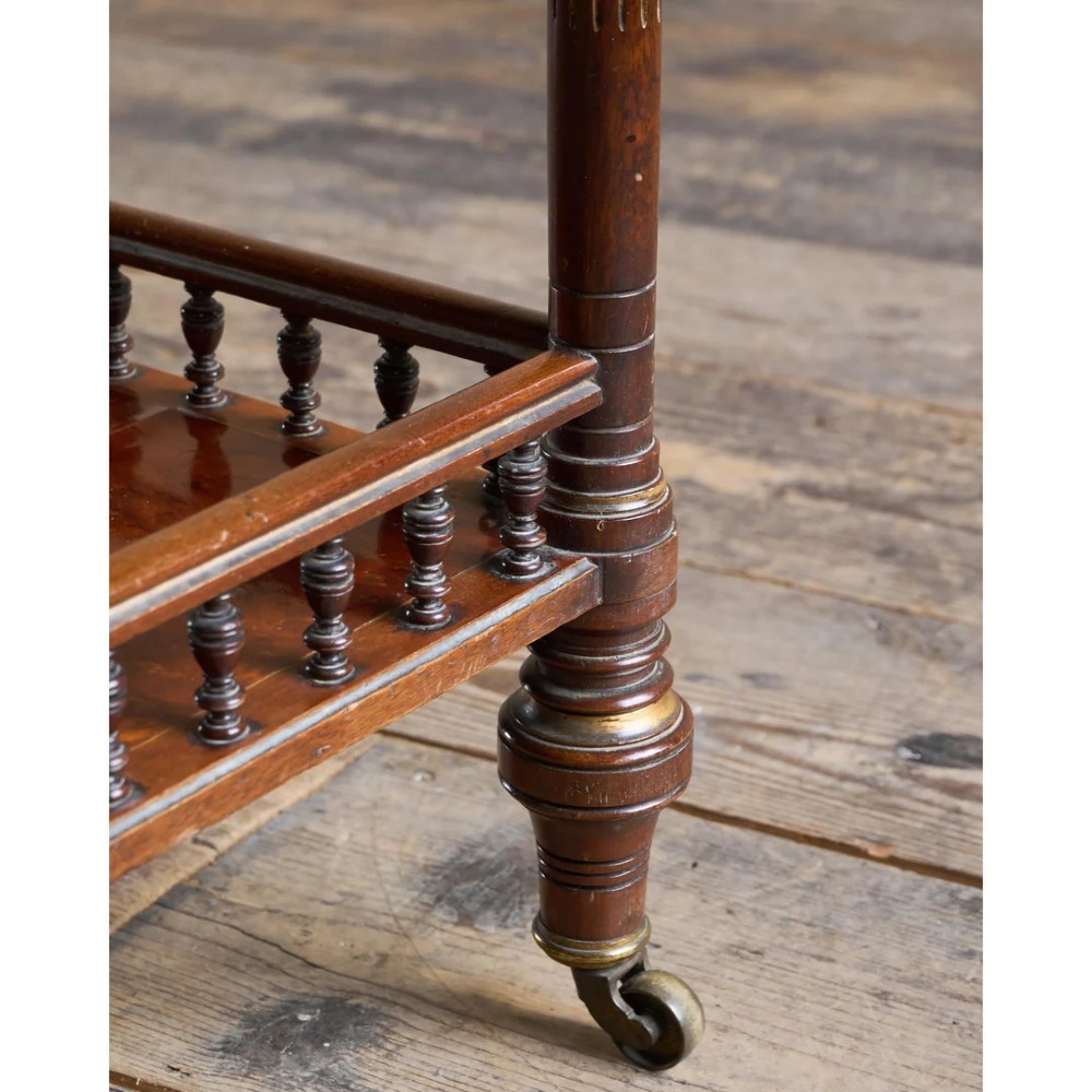 An octagonal Victorian side table featuring an amboyna wood veneer top with gilt borders, turned legs, a lower shelf with a spindle gallery, and brass castors. View XIV