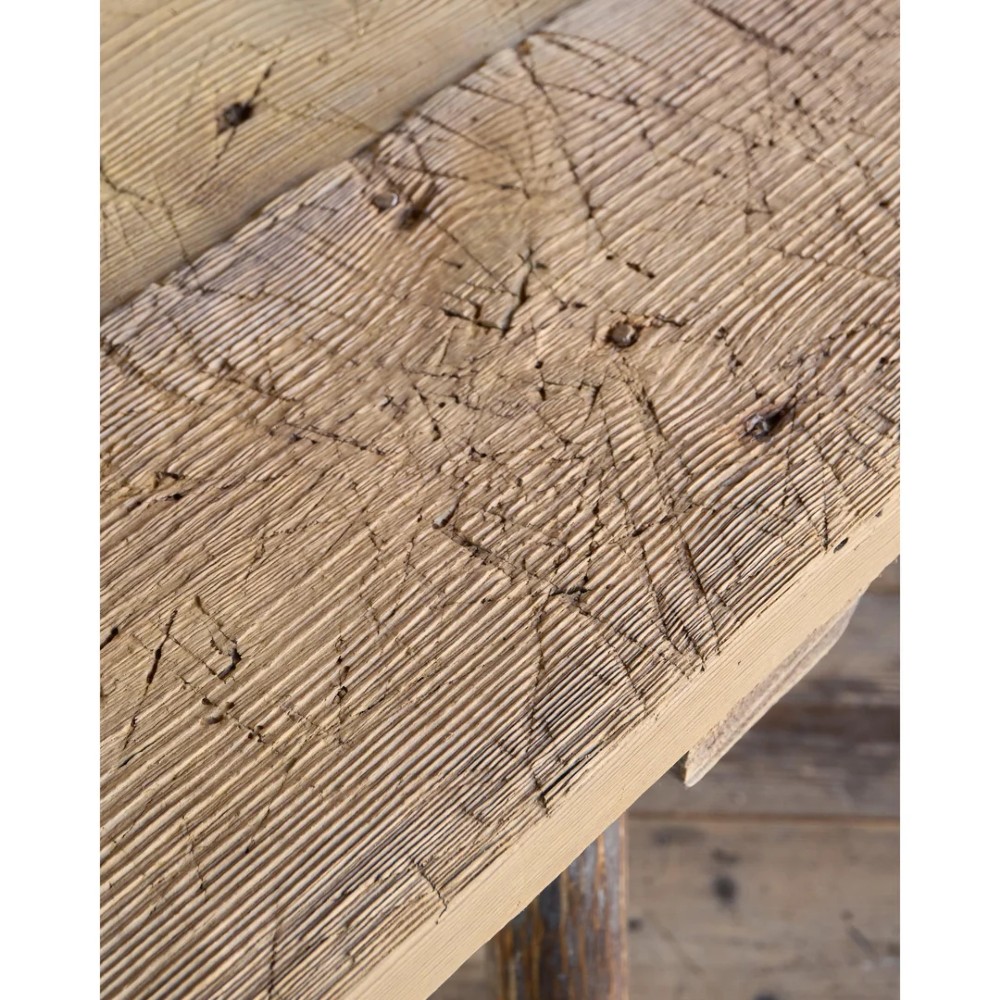 A primitive rustic dining table constructed from weathered pale timber with a rough-hewn plank top and diagonal cross-braced legs. View IX
