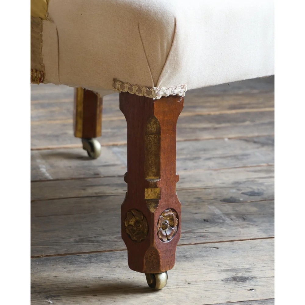 A low Victorian upholstered armchair featuring a deep button-backed yellow damask backrest, a plain off-white seat, and carved mahogany front legs on brass castors. View IX