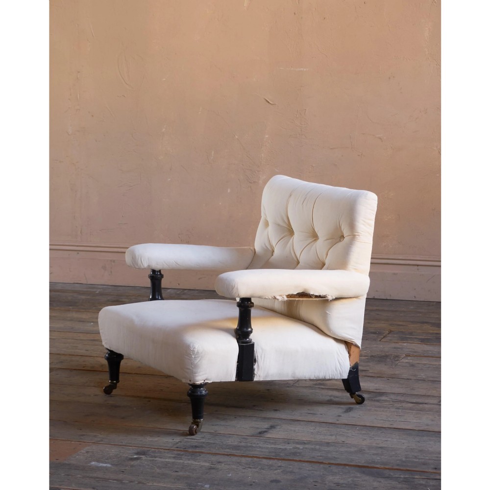An antique Victorian open armchair upholstered in off-white calico fabric featuring a deep-buttoned backrest, padded arms, turned dark timber supports, and legs on castors. View II