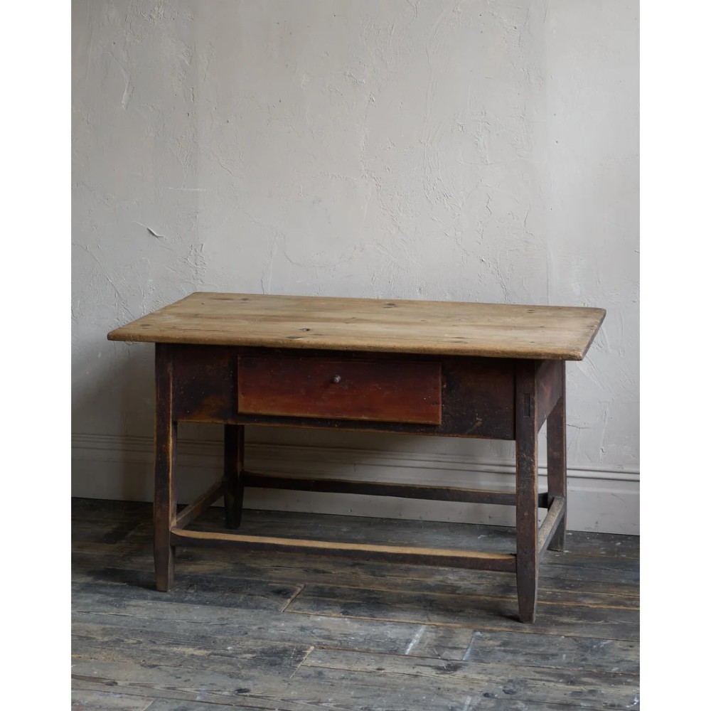 A rustic Swedish painted pine table featuring a scrubbed rectangular top, single frieze drawer, and dark painted base with box stretchers. View V