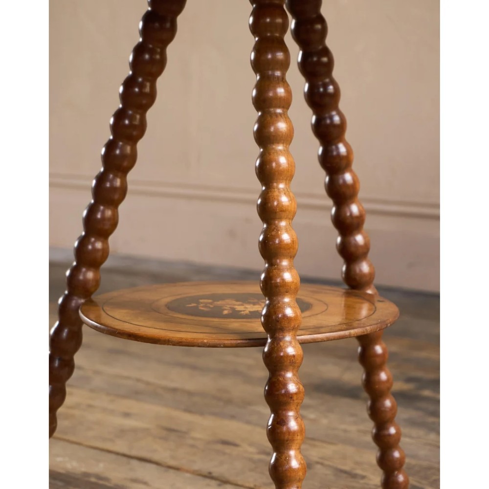A circular warm brown wooden side table featuring floral marquetry inlays on the tabletop and lower shelf, supported by four bobbin-turned legs. View II