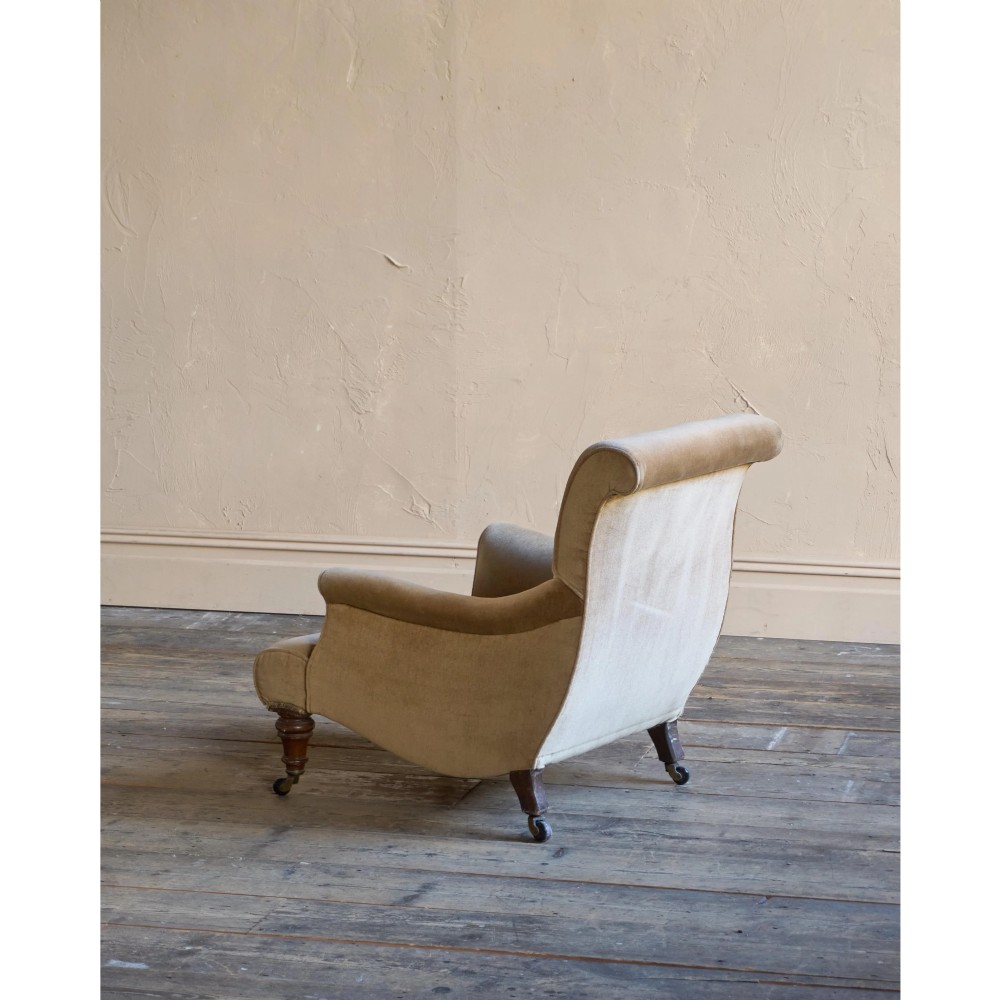 A Victorian button-back armchair upholstered in taupe velvet with turned front wooden legs set on metal castors. View III