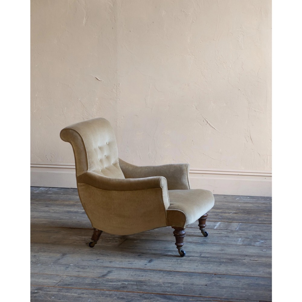 A Victorian button-back armchair upholstered in taupe velvet with turned front wooden legs set on metal castors. View IV