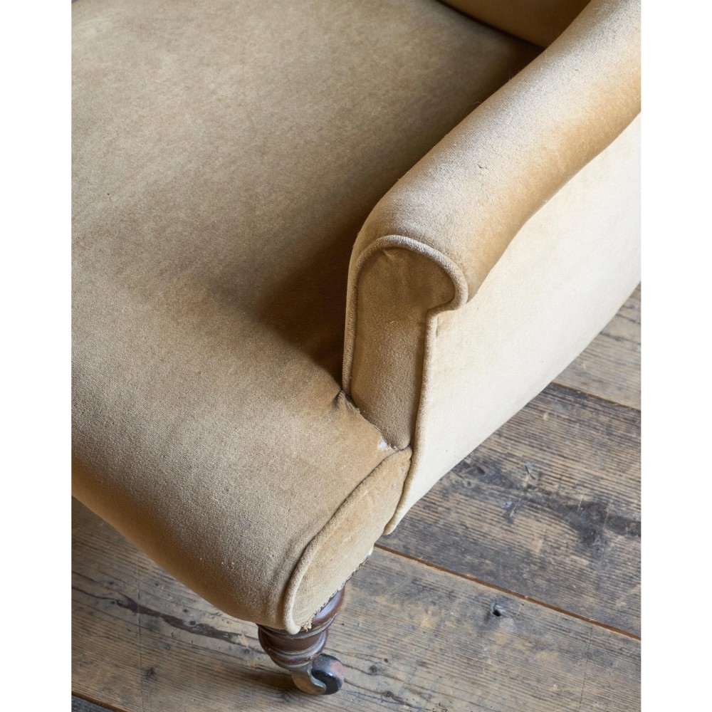 A Victorian button-back armchair upholstered in taupe velvet with turned front wooden legs set on metal castors. View VII