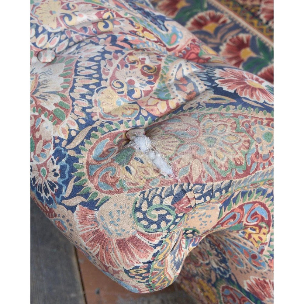 A Victorian Chesterfield sofa featuring deep-buttoned floral pattern upholstery, rolled arms, and turned wooden legs fitted with brass castors. View VII