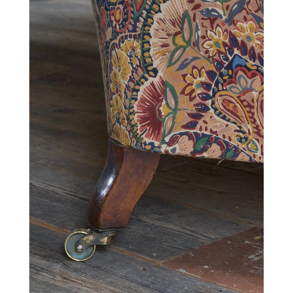 A Victorian Chesterfield sofa featuring deep-buttoned floral pattern upholstery, rolled arms, and turned wooden legs fitted with brass castors. View XI