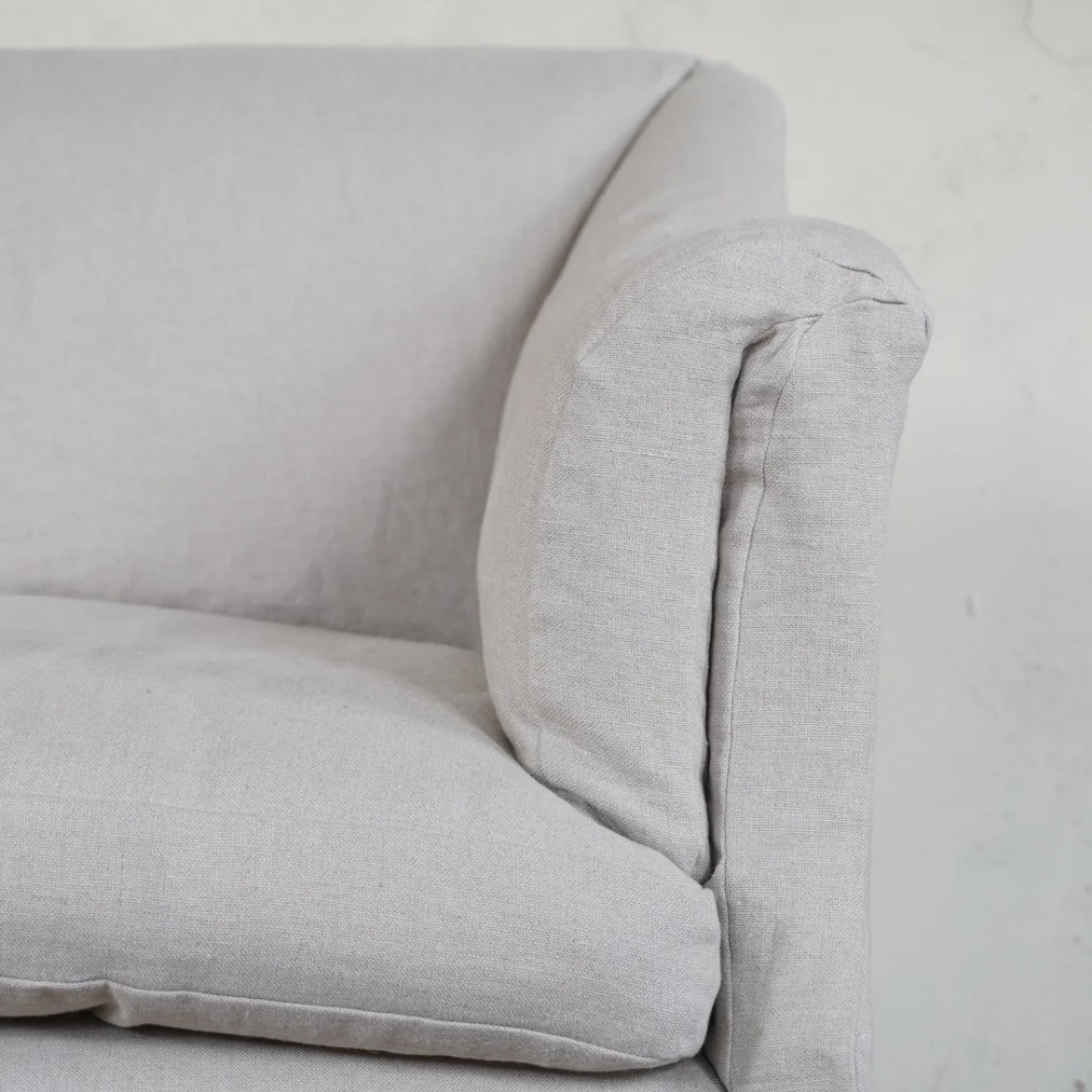 A two-seater Howard style sofa with sloped arms, grey geometric patterned upholstery, turned timber front legs, and brass castors. View IX