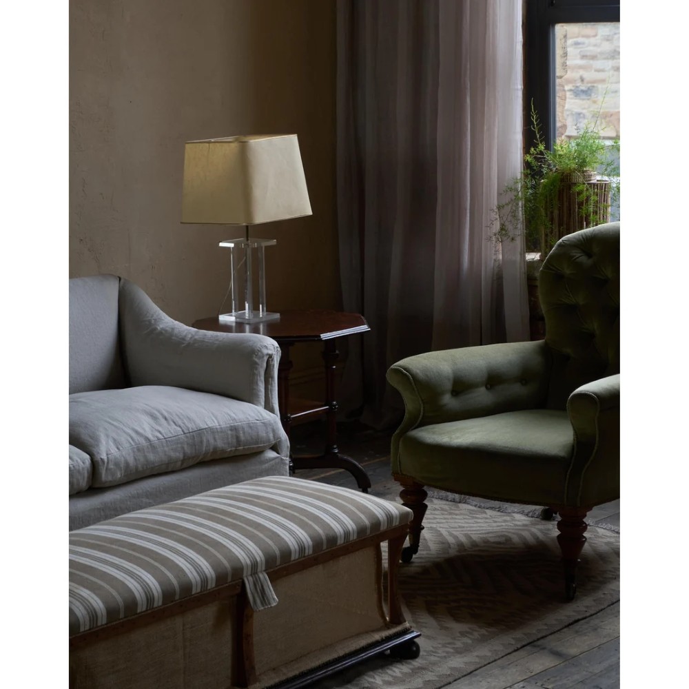 A two-seater Howard style sofa with sloped arms, grey geometric patterned upholstery, turned timber front legs, and brass castors. View XIII