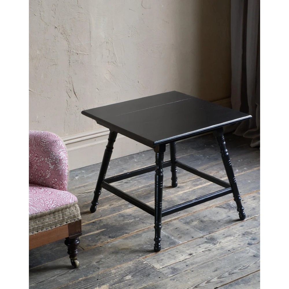 A square ebonised wood side table featuring slender turned legs connected by a lower square stretcher frame.