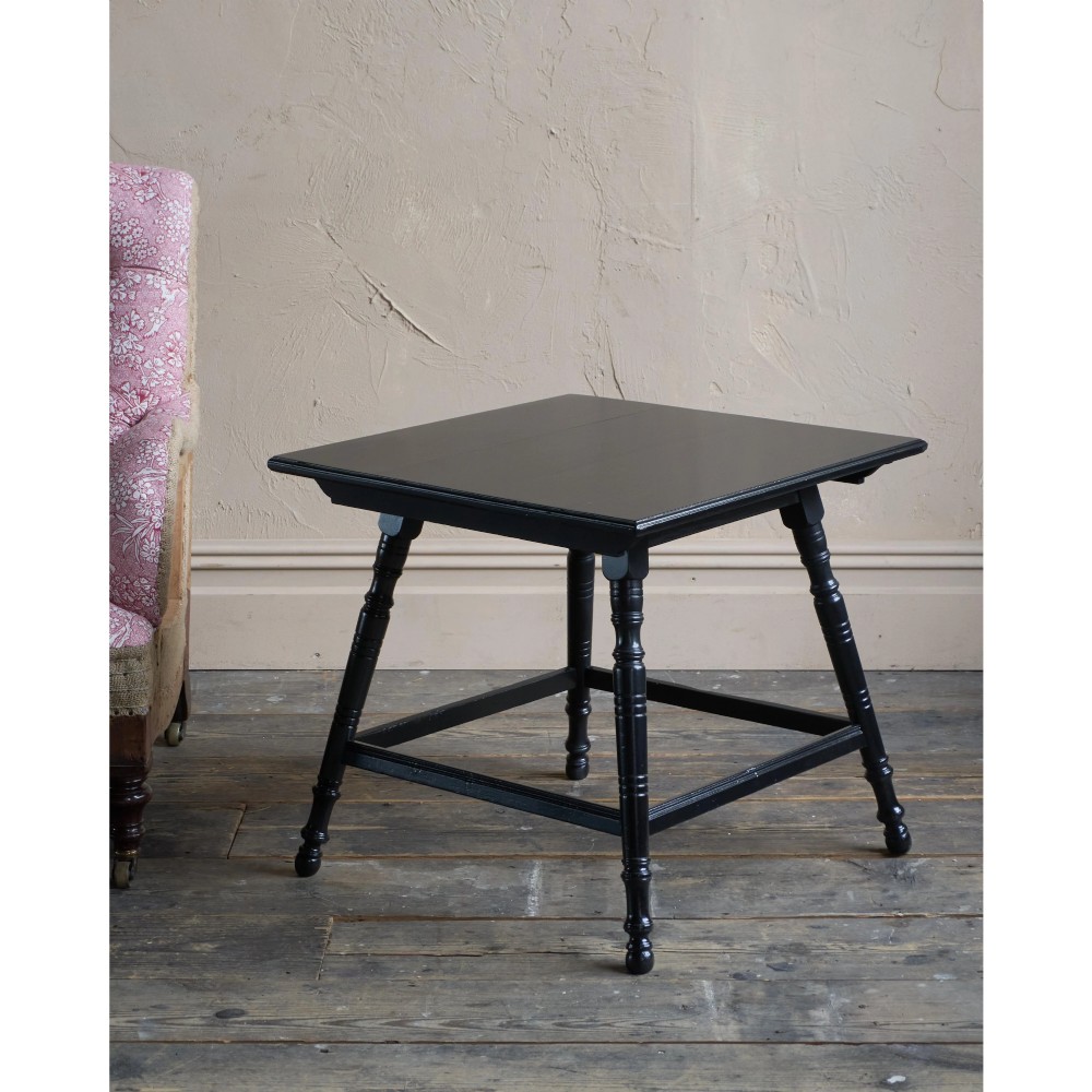 A square ebonised wood side table featuring slender turned legs connected by a lower square stretcher frame. View II