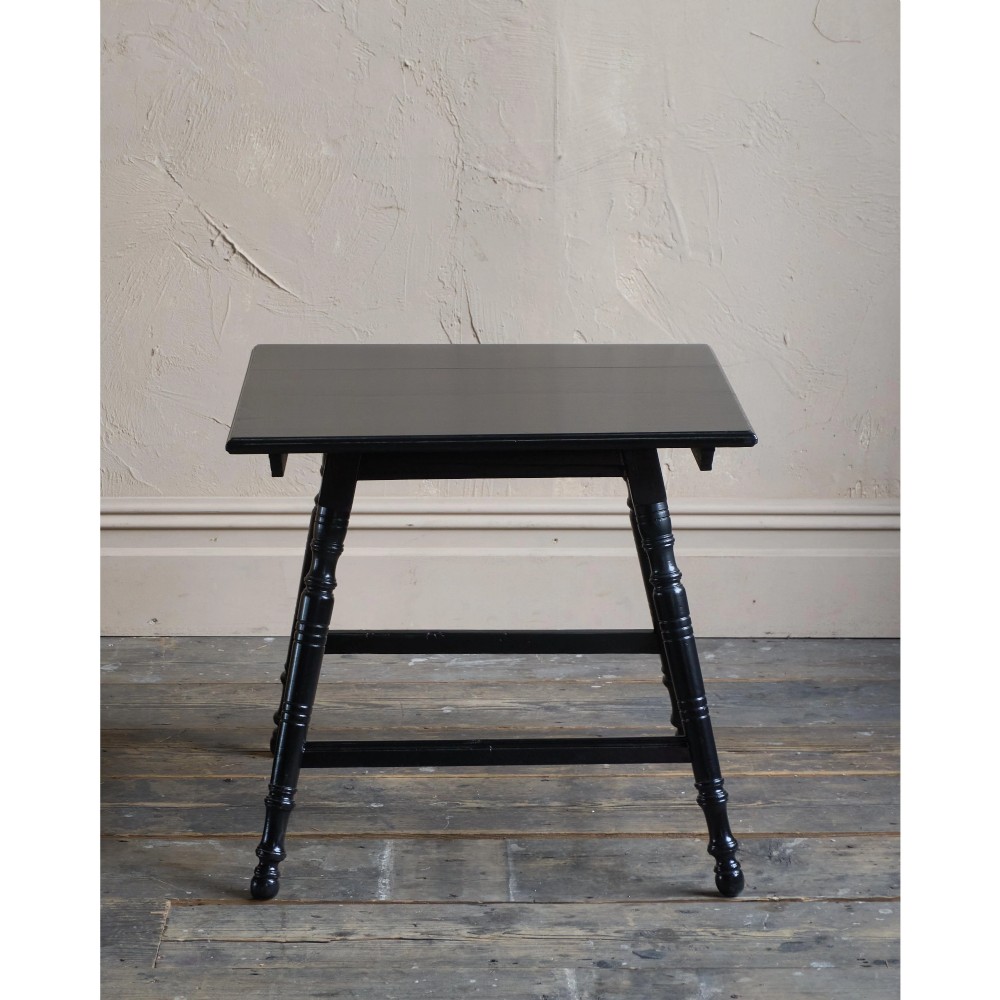 A square ebonised wood side table featuring slender turned legs connected by a lower square stretcher frame. View IV