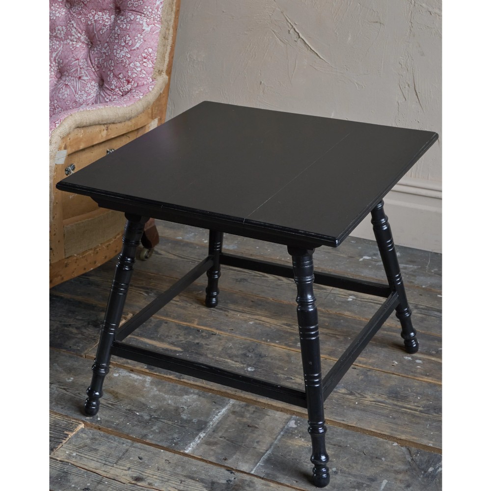 A square ebonised wood side table featuring slender turned legs connected by a lower square stretcher frame. View VI