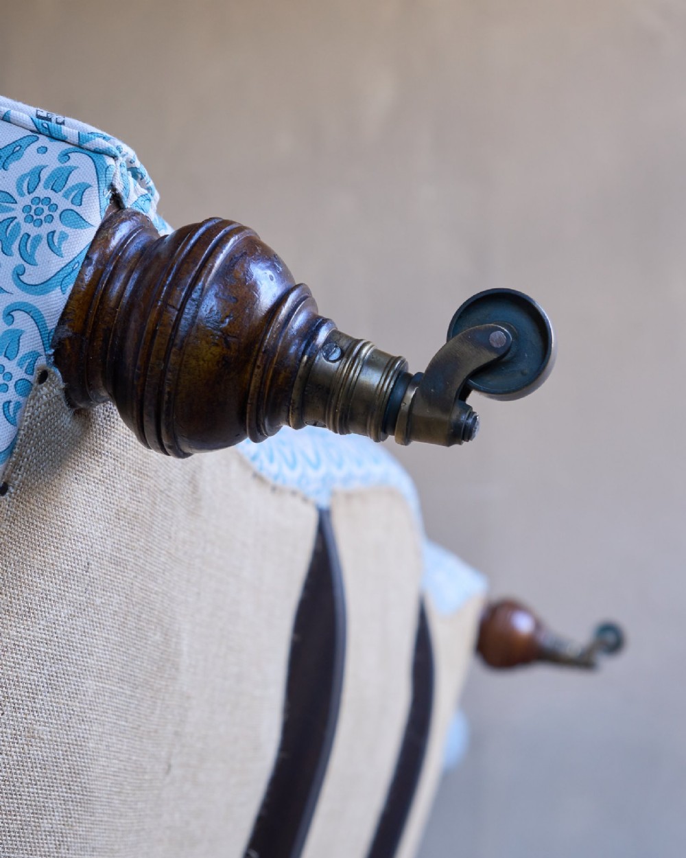A pair of antique serpentine Chesterfield sofas featuring light blue patterned fabric, deep button-tufted backrests, rolled arms, and turned wooden legs on brass castors. View XIV