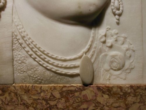 fig 6. A pair of square carved white marble relief plaques depicting portrait busts set within ochre marble frames.