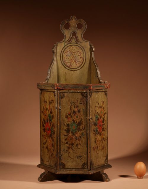 fig 1. An 18th-century miniature Dutch Hindeloopen style green painted wooden doll chair featuring hand-painted floral motifs and an enclosed cabinet base.