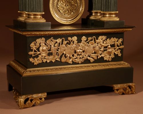 fig 1. A late nineteenth-century French portico clock featuring dark patinated bronze columns, decorative gilt bronze mounts, a white enamel dial with Roman numerals, and an ornate pendulum.