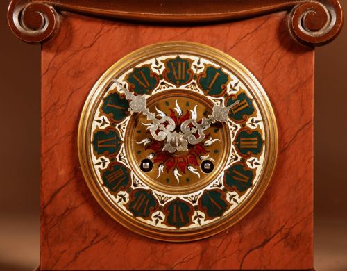 fig 1. A 19th-century bronze and red marble mantel clock featuring a pensive classical male figure seated above an ornate circular dial.
