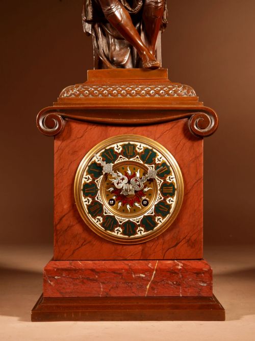 fig 2. A 19th-century bronze and red marble mantel clock featuring a pensive classical male figure seated above an ornate circular dial.