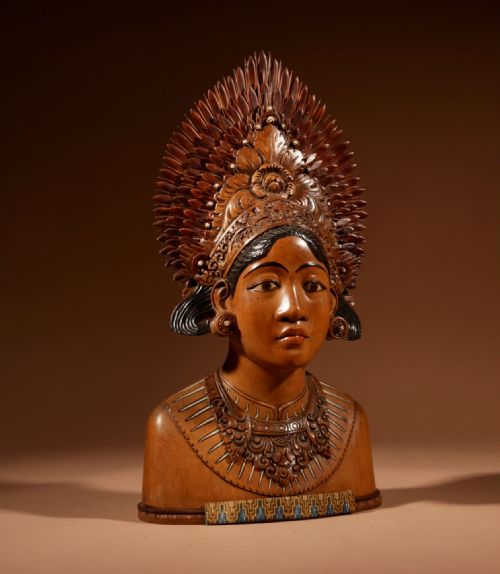 fig 1. A carved wooden bust depicting an Indonesian Janger dancer with a detailed spiked fan headdress, ornate painted collar, and expressive facial features.