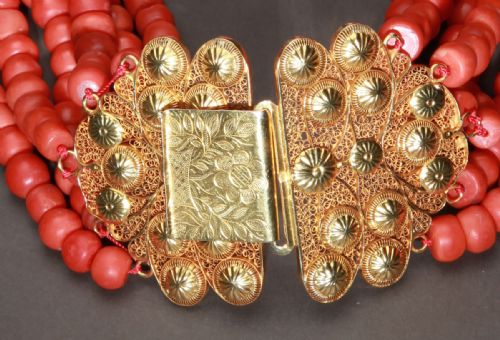 fig 2. A six-strand natural red coral bead necklace featuring intricate gold filigree clasps decorated with beaded granulation at each end.