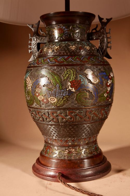 fig 2. An antique Japanese champleve bronze vase converted into a table lamp, featuring dragon motifs, twin handles, colourful enamel inlay, and topped with a pleated cream lampshade.