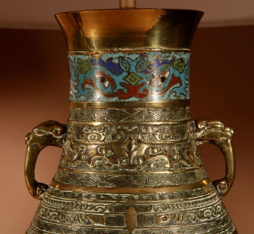fig 2. A pair of Japanese brass vase-form table lamps decorated with polychrome champleve enamel and topped with pleated cream fabric shades.
