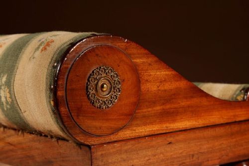 A 19th-century Continental mahogany sloped footstool featuring striped floral upholstery, brass side rosettes, and turned bun feet. View IV