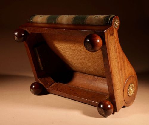A 19th-century Continental mahogany sloped footstool featuring striped floral upholstery, brass side rosettes, and turned bun feet. View VIII