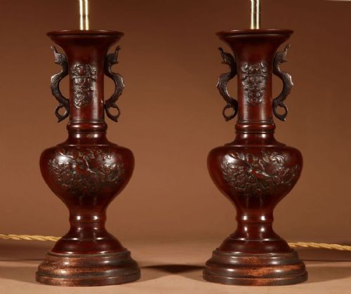 A pair of dark Japanese bronze baluster vase lamps featuring relief carvings and fitted cream pleated shades. View III