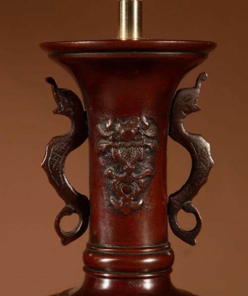 A pair of dark Japanese bronze baluster vase lamps featuring relief carvings and fitted cream pleated shades. View IV