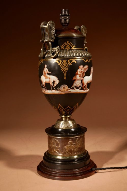 A 19th-century Grand Tour table lamp featuring a black ceramic urn base with red-figure chariot artwork, gilt bronze handles, and a pleated conical fabric shade. View IV