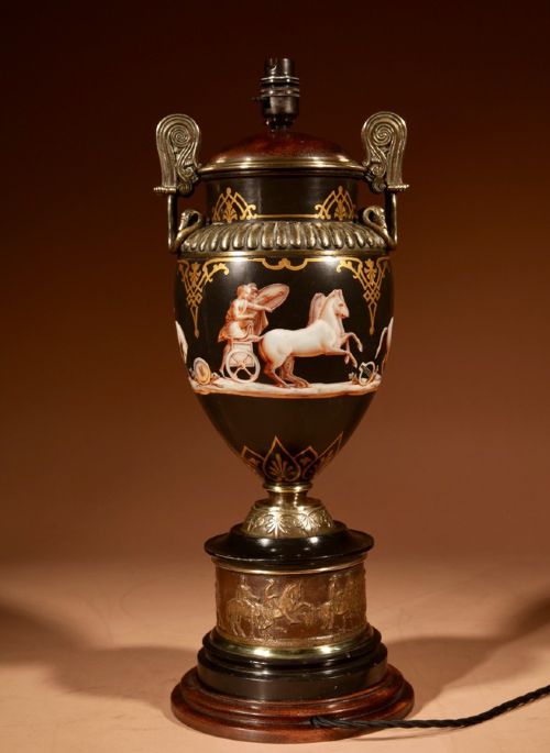 A 19th-century Grand Tour table lamp featuring a black ceramic urn base with red-figure chariot artwork, gilt bronze handles, and a pleated conical fabric shade. View V