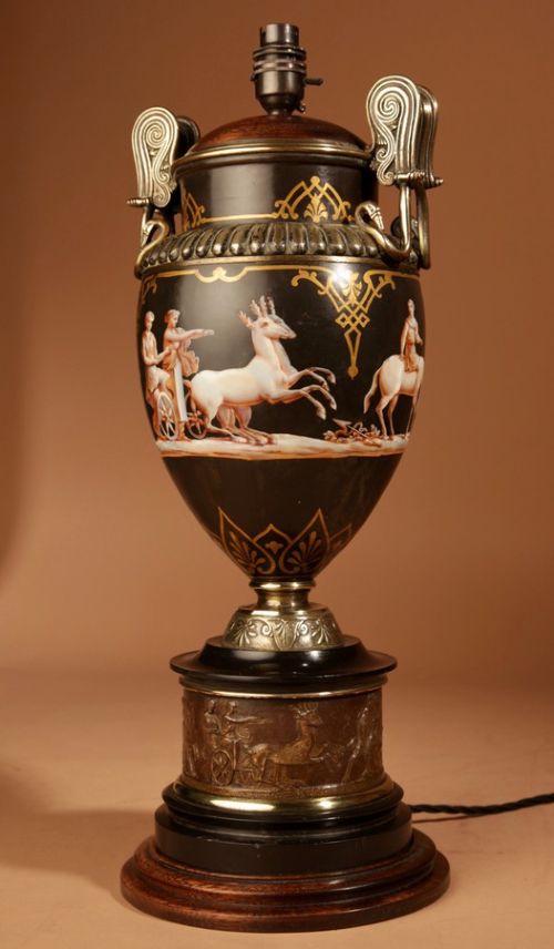 A 19th-century Grand Tour table lamp featuring a black ceramic urn base with red-figure chariot artwork, gilt bronze handles, and a pleated conical fabric shade. View VIII