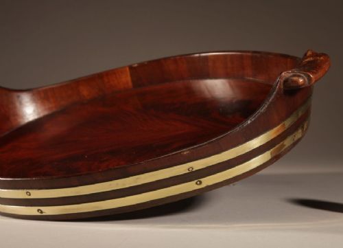 An oval mahogany serving tray featuring staved wood construction, twin carved side handles, and two horizontal brass bands securing the outer rim. View II