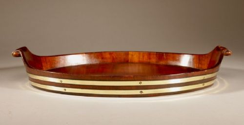 An oval mahogany serving tray featuring staved wood construction, twin carved side handles, and two horizontal brass bands securing the outer rim. View VI