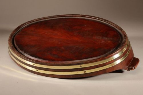 An oval mahogany serving tray featuring staved wood construction, twin carved side handles, and two horizontal brass bands securing the outer rim. View VIII